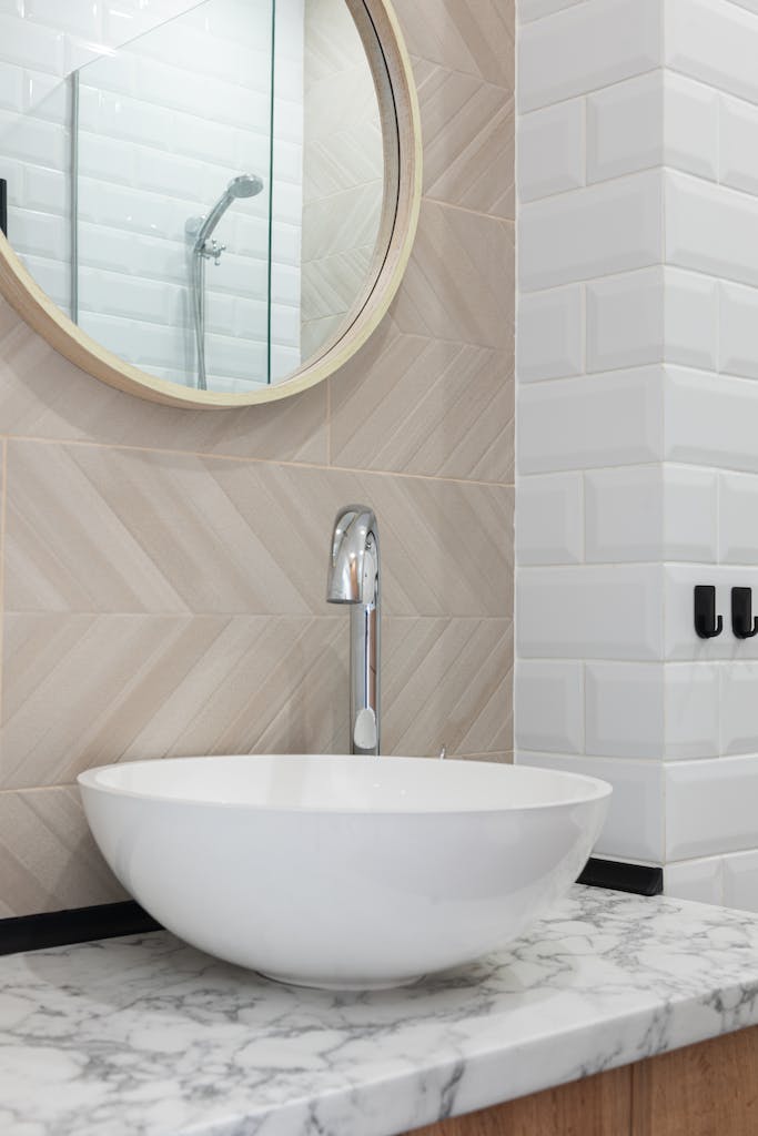 interior of light modern restroom with sink and faucet on cabinet under mirror on tile wall 6782428 683x1024