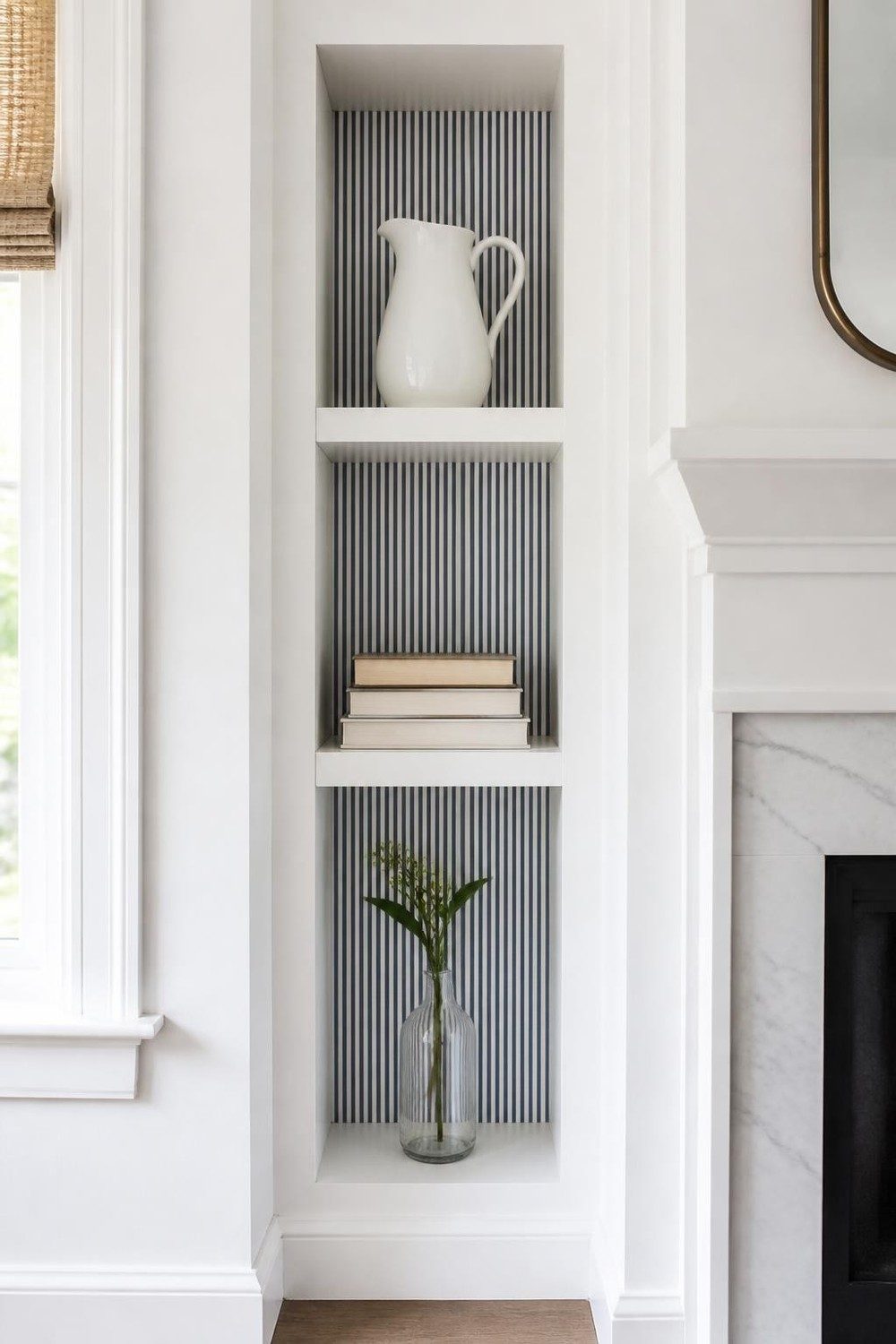 Tall narrow wall niche with navy ticking stripe wallpaper and white shelves